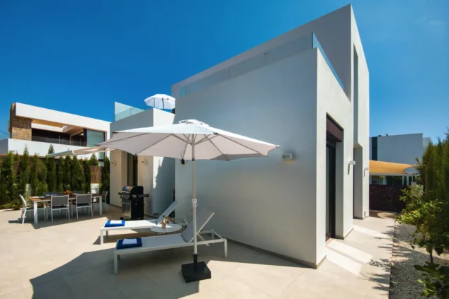 Villa San Juan: la espectacular villa moderna y con mucho estilo en Dénia perfecta para tus vacaciones 17 zona de comedor exterior con barbacoa y tumbonas