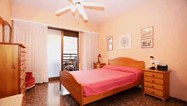 dormitorio doble con ventilador de techo y salida a la terraza