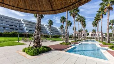 Apartamento en urbanización de lujo con palmeras y piscina de estilo balinés
