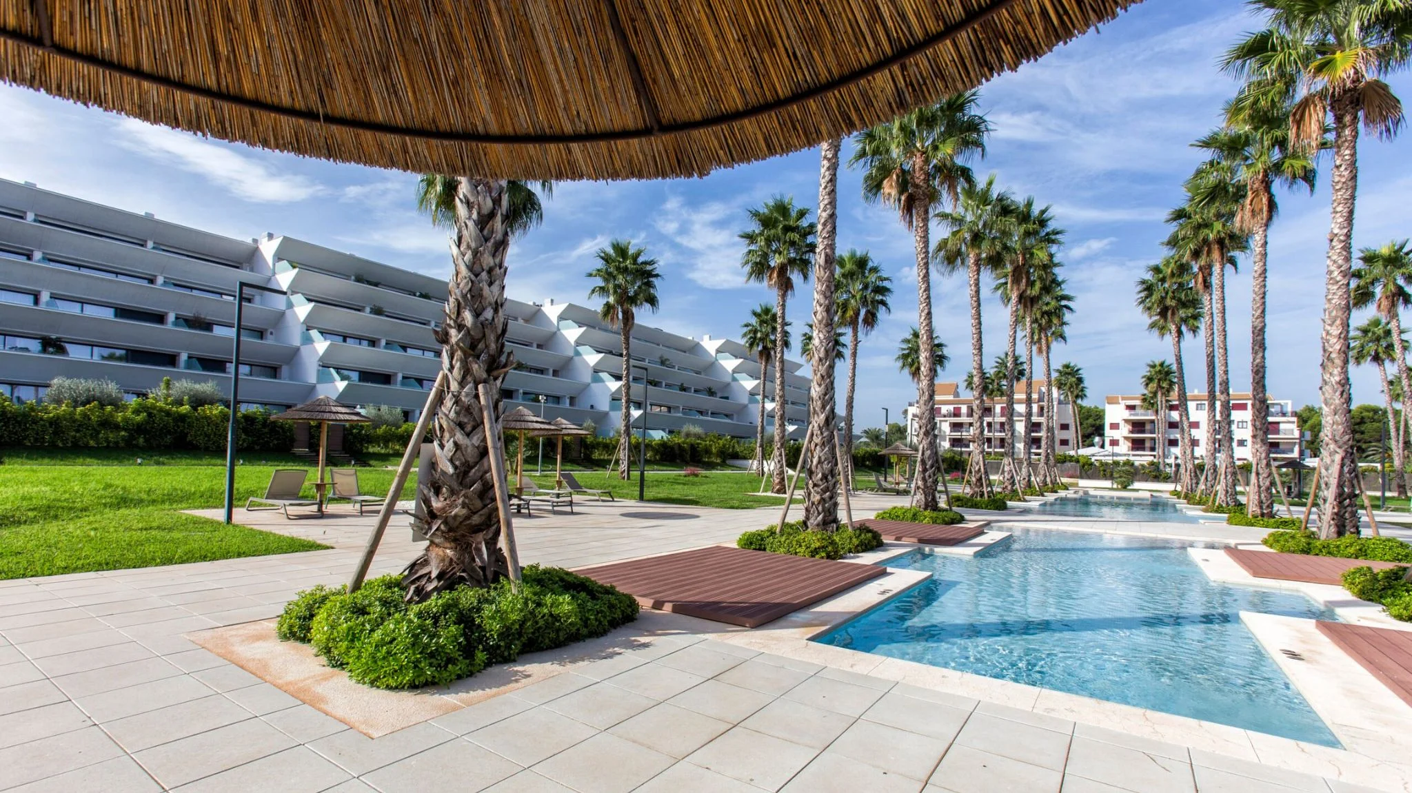 Apartamento en urbanización de lujo con palmeras y piscina de estilo balinés
