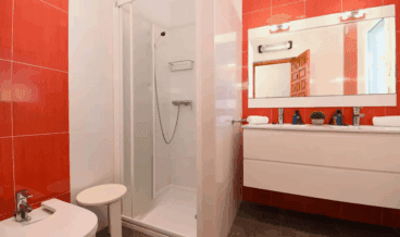 Baño de la vivienda con ducha y dos lavabos