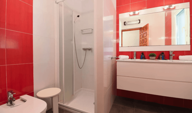 bancc83o de la vivienda con ducha y dos lavabos