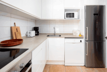 Cocina de la vivienda con muebles en blanco y encimera en tono beige