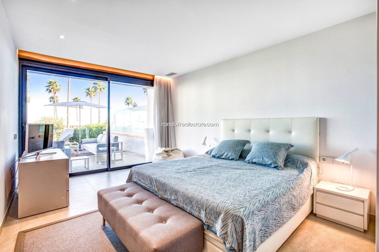 Dormitorio principal con cama de matrimonio y acceso a la terraza