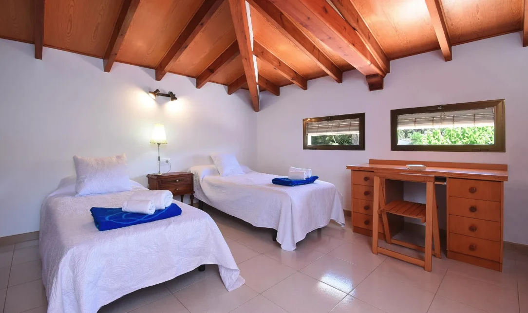 Dormitorio rústico con techo de madera y dos camas individuales