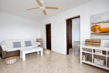 Sala de estar con sofá y ventilador de techo