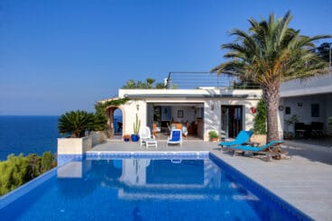 Villa con diversas zonas de descanso junto a la piscina infinity