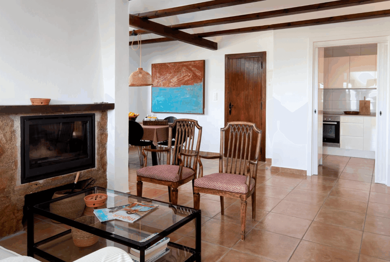Zona del salón con chimenea y acceso a la cocina