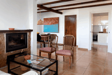 Zona del salón con chimenea y acceso a la cocina