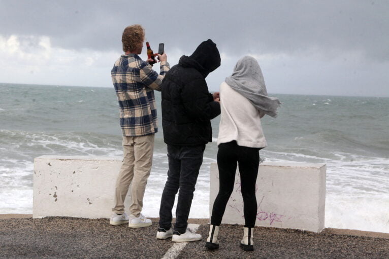 Jóvenes sacando fotos del temporal en Les Rotes