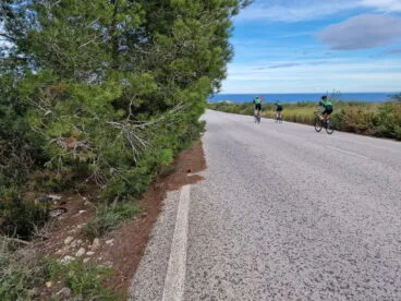 ciclistas circulando por les planes con un carril invadido por la vegetacion