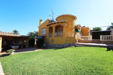 Fachada de la vivienda de dos plantas con jardín