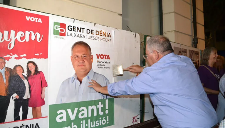 Марио Видаль расклеивает плакаты во время последней избирательной кампании