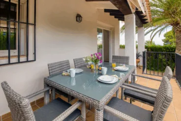 Terraza cubierta con conjunto de comedor exterior