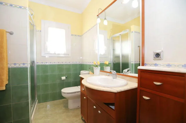 uno de los bancc83os de la vivienda euipado con plato de ducha y un lavabo