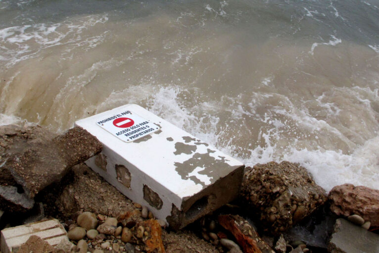 Señal de prohibido el paso arrancada por un temporal en la desaparecida playa de Les Deveses de Dénia