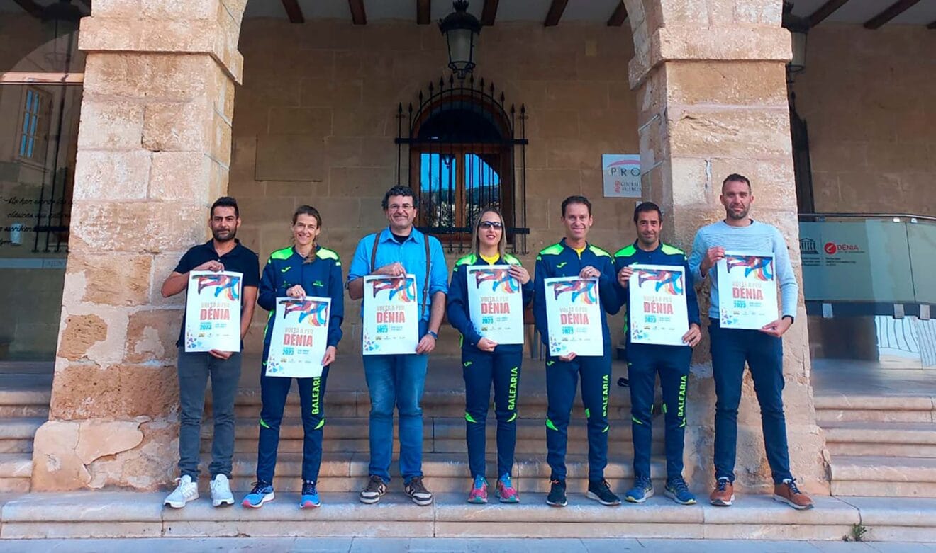 Miembros del Dénia Corre junto al concejal Raúl García de la Reina sosteniendo los carteles de La Volta a Peu