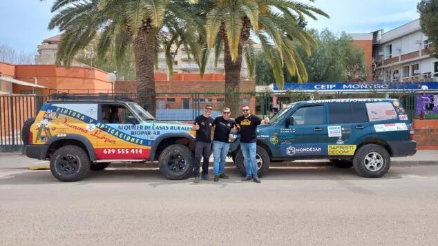 vehiculos participantes en el proyecto llenemos de dibujos el desierto frente a un colegio de denia