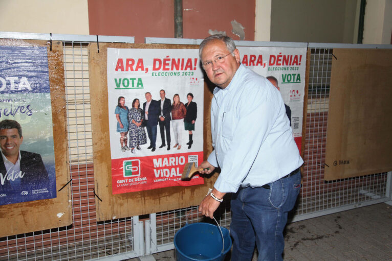 Mario Vidal col·locant un cartell de Gent de Dénia