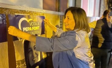 pepa font colocando un cartel electoral de su candidatura