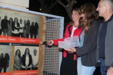 Susana Mut pegando el cartel de Ciudadanos Dénia