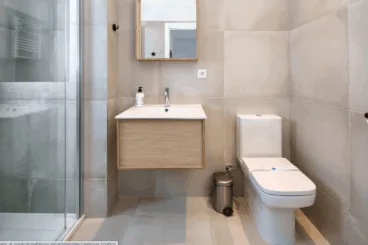 Uno de los baños, equipado con plato de ducha y mampara