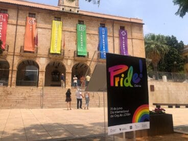 Atril del Orgullo con el ayuntamiento de Dénia de fondo