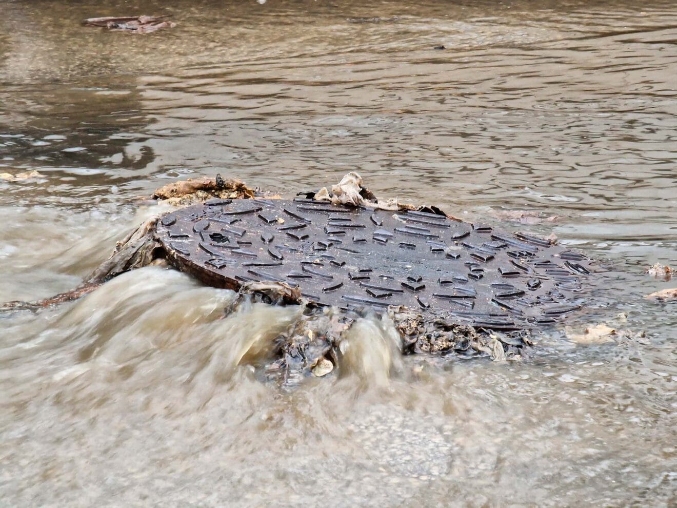 Alcantarilla expulsando suciedad por el agua