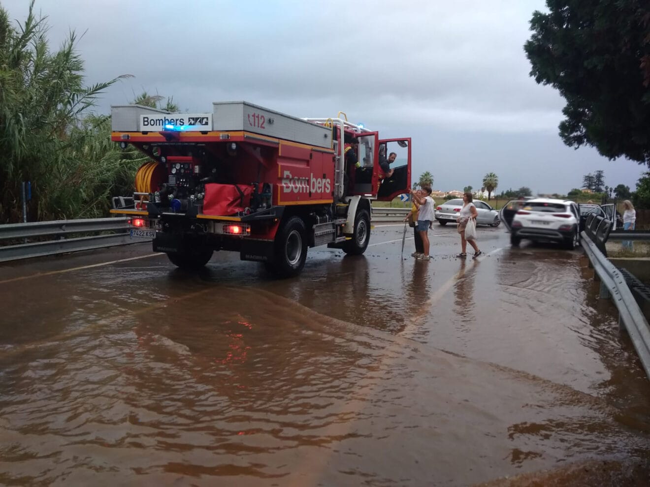 Bomberos ayudan a los coches detenidos por la lluvia en Dénia