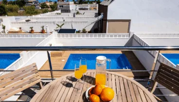 Mesa de exterior en balcón con vistas a la piscina