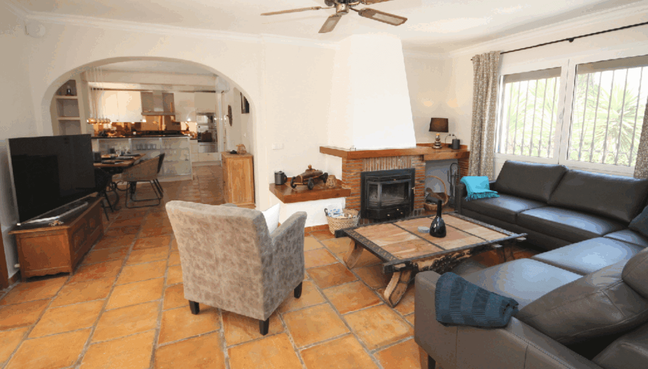Salón con tonos madera y una gran chimenea de protagonista