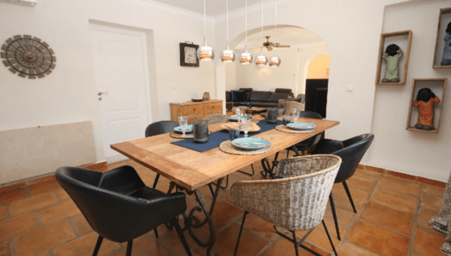 una mesa de madera natural en el comedor de esta villa