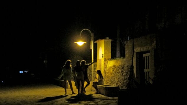 grupo de jovenes de noche en un paseo del litoral de denia