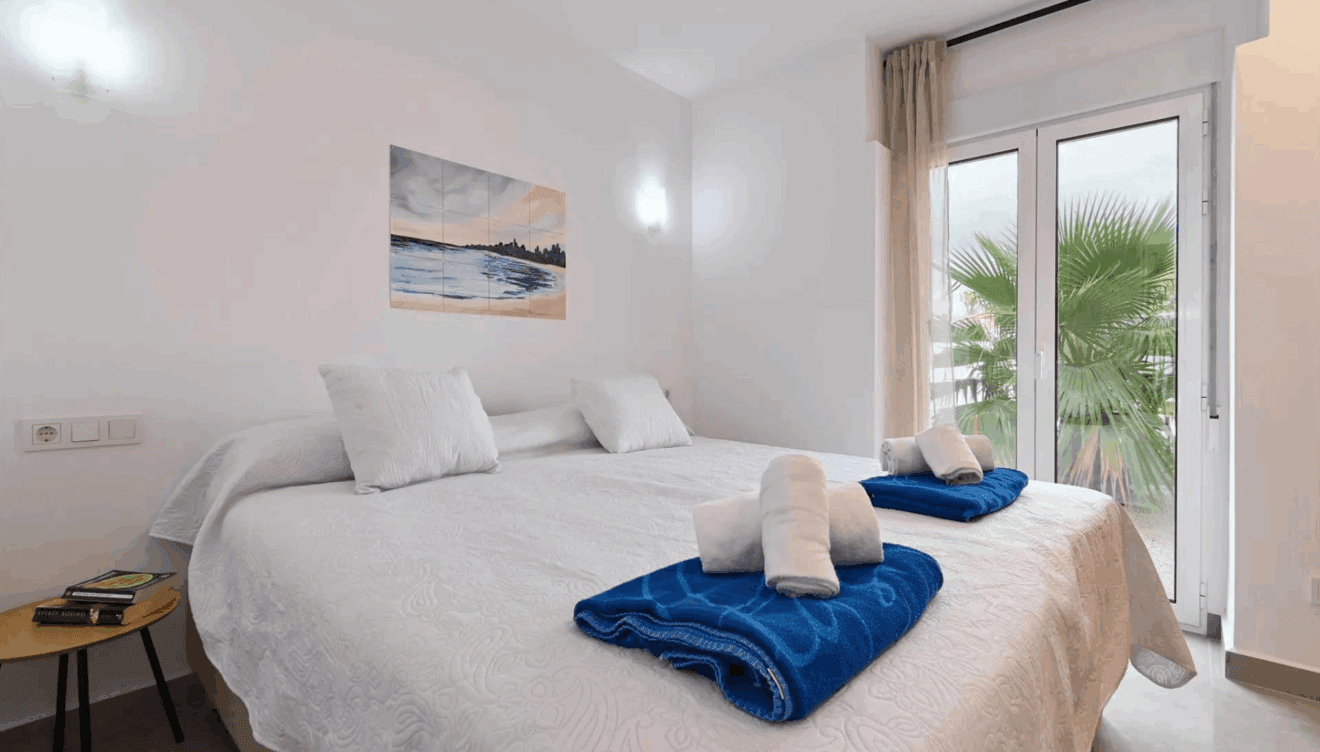 Dormitorio con cama de matrimonio y acceso al jardín
