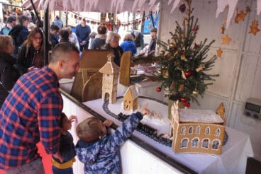 Vecinos admiran un puesto del Mercado de Navidad