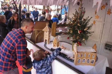 Vecinos admiran un puesto del Mercado de Navidad