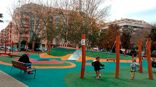 Imagen: Adulto con el teléfono móvil mientras los menores juegan en un parque de Dénia