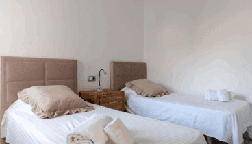 Dormitorio con dos camas individuales decorada en tonos neutros