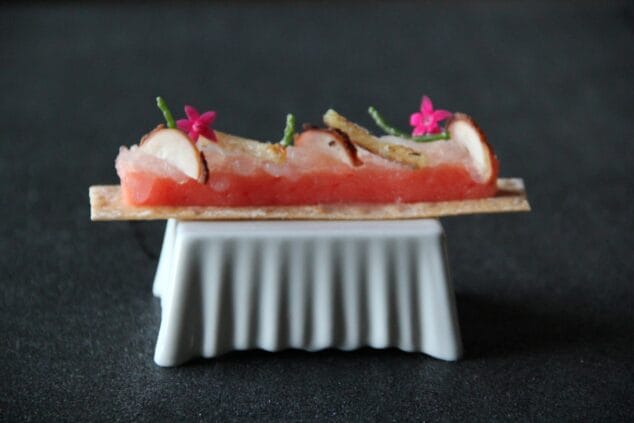 Imagen: Tosta con regañada esponja de tomate , gel de lechuga con pulpo seco y capellán