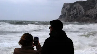 Pareja joven fotografiando la playa de Dénia