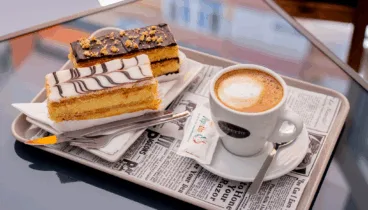 Milhojas de crema y chocolate junto con un café arábico 100%