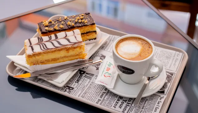 milhojas de crema y chocolate junto con un cafe arabico 100