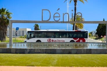 Nuevo autobús urbano híbrido de la flota BusDénia circulando junto al icónico monumento de entrada a la ciudad
