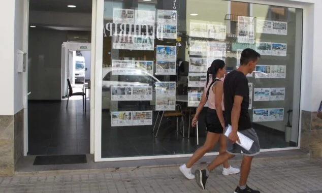 Imagen: Jóvenes paseando frente a una inmobiliaria