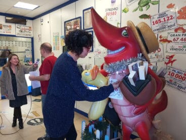 Trabajadores de la administración poniendo el número premiado en la gamba roja de Dénia