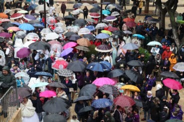 falleros bajo los paraguas para resguardarse de las lluvias