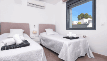 Dormitorio con dos camas individuales y televisión