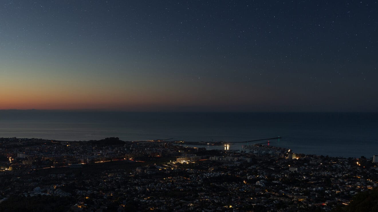El puerto de Dénia desde la Cova de l'Aigua en el Montgó casi a oscuras - Fotografía de Fran Martínez
