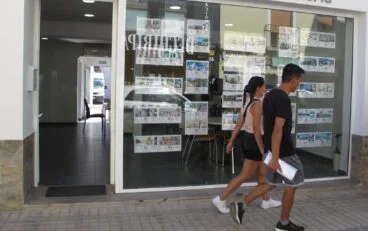 viandantes frente al escaparate de una inmobiliaria de denia