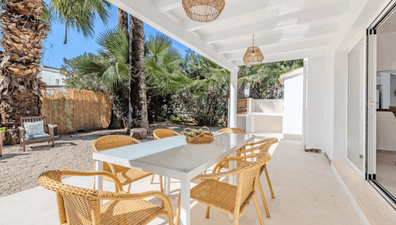 Zona de comedor exterior bajo el porche cubierto